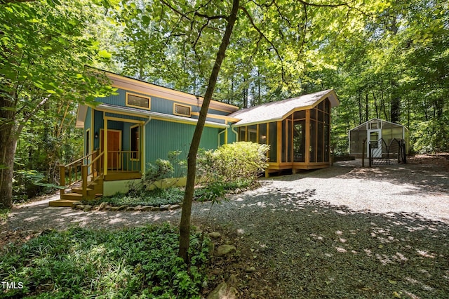 9709 Greenfield Rd, Chapel Hill, NC 27516 - back of property with a sunroom, a carport, and an outdoor structure