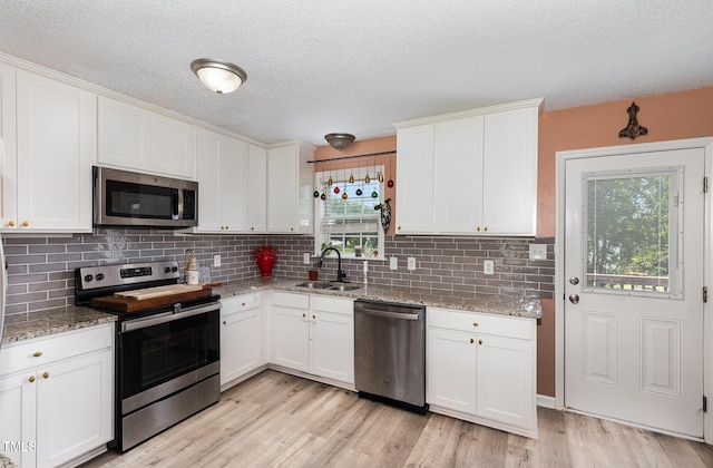 11 Sherman Rd, Fuquay Varina, NC 27526 - kitchen with appliances with stainless steel finishes, plenty of natural light, white cabinetry, and a textured ceiling