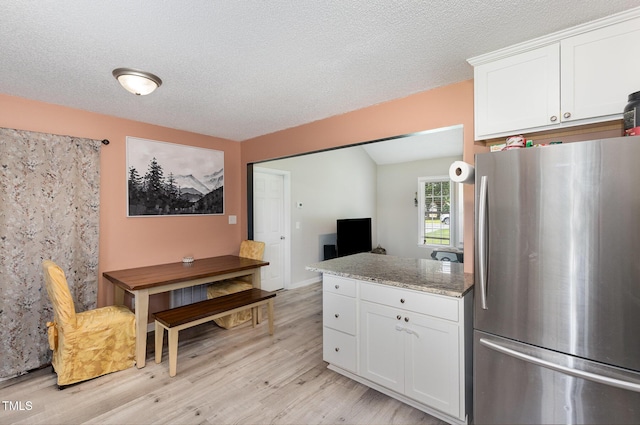 11 Sherman Rd, Fuquay Varina, NC 27526 - kitchen with freestanding refrigerator, light wood-type flooring, white cabinets, a peninsula, and vaulted ceiling