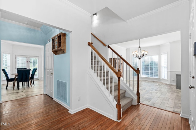 5125 Pinehall Wynd, Raleigh, NC 27604 - stairway with wood-type flooring, a chandelier, healthy amount of natural light, and crown molding