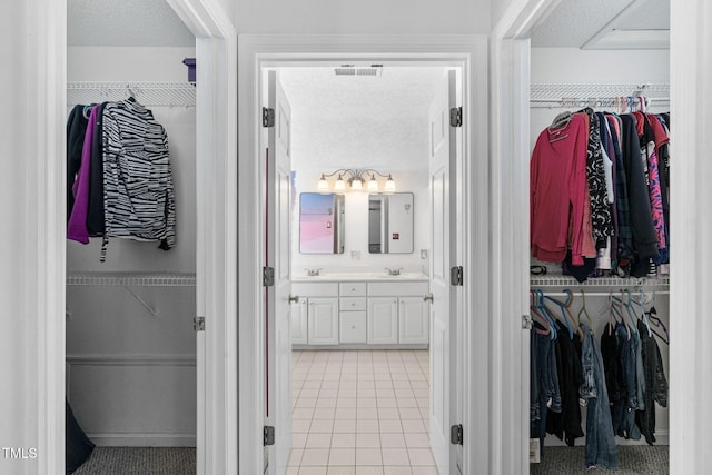5125 Pinehall Wynd, Raleigh, NC 27604 - full bathroom featuring a spacious closet, double vanity, a textured ceiling, and tile patterned floors