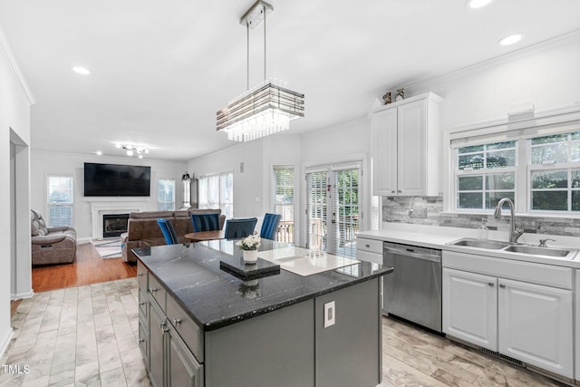 5125 Pinehall Wynd, Raleigh, NC 27604 - kitchen featuring dishwasher, crown molding, a kitchen island, a fireplace with raised hearth, and white cabinets