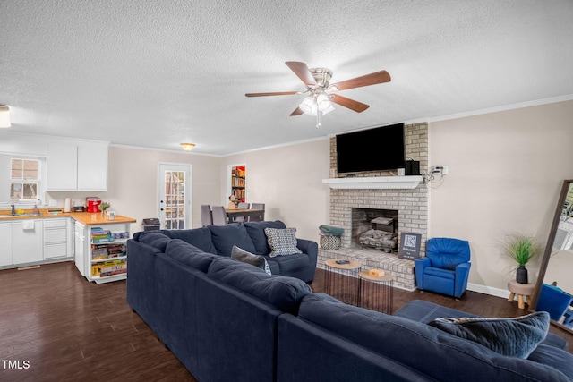 117 James Dr, Pine Level, NC 27568 - living room featuring dark wood finished floors, a textured ceiling, ceiling fan, crown molding, and a fireplace