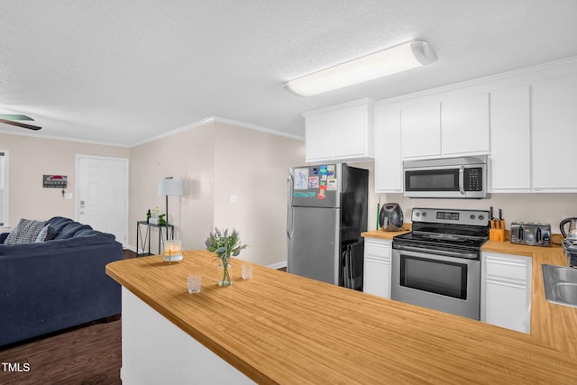 117 James Dr, Pine Level, NC 27568 - kitchen featuring appliances with stainless steel finishes, a textured ceiling, open floor plan, butcher block counters, and white cabinets