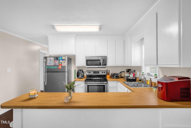 117 James Dr, Pine Level, NC 27568 - kitchen featuring appliances with stainless steel finishes, white cabinets, crown molding, light countertops, and a peninsula