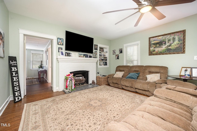 900 Beaman St, Clinton, NC 28328 - living room featuring ceiling fan, dark wood-style flooring, a fireplace, and built in shelves