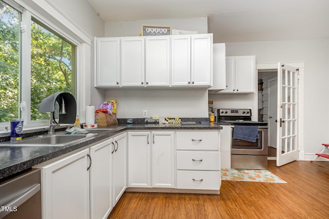 900 Beaman St, Clinton, NC 28328 - kitchen with appliances with stainless steel finishes, light wood-style flooring, and white cabinets