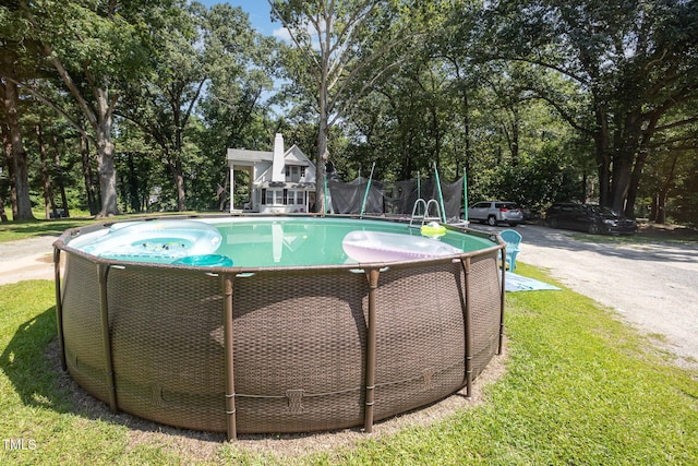 900 Beaman St, Clinton, NC 28328 - view of swimming pool featuring view of wooded area, a trampoline, and a yard