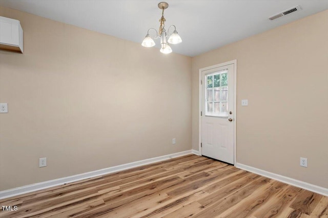 1611 Poole Rd, Raleigh, NC 27610 - unfurnished dining area with light wood-style floors and a chandelier