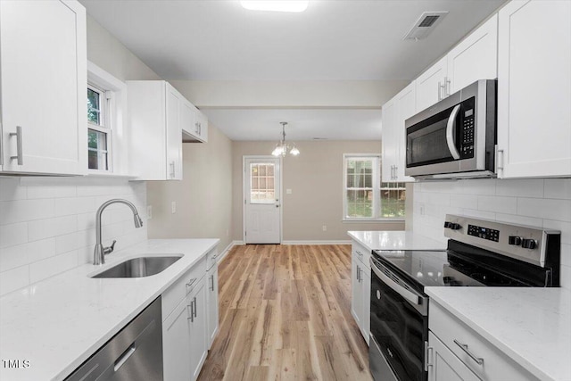 1611 Poole Rd, Raleigh, NC 27610 - kitchen with stainless steel appliances, light wood finished floors, white cabinets, and light stone counters