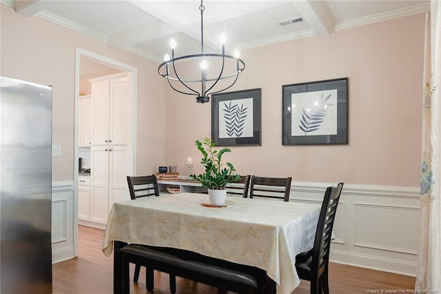 688 Townsend Rd, Raeford, NC 28376 - dining space with a chandelier, beam ceiling, light wood-style flooring, ornamental molding, and a wainscoted wall