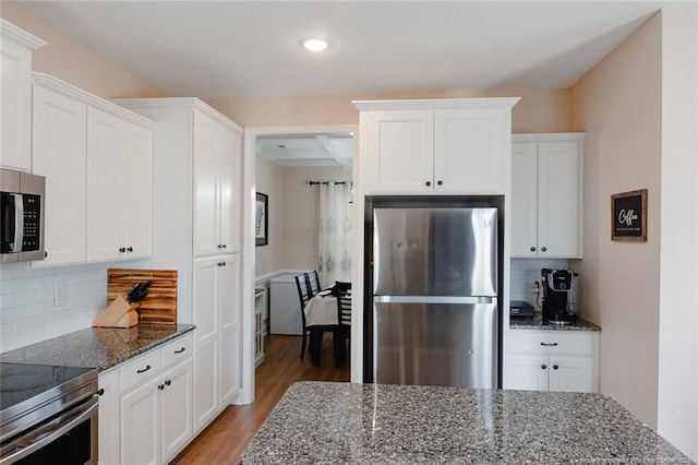 688 Townsend Rd, Raeford, NC 28376 - kitchen with stainless steel appliances, light wood-type flooring, dark stone counters, white cabinets, and recessed lighting
