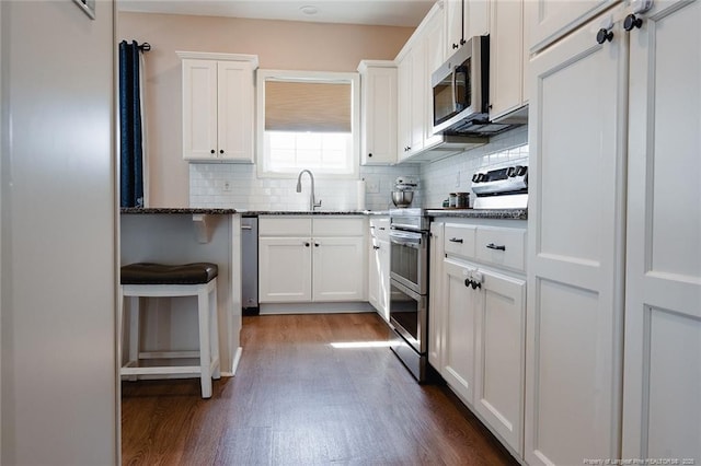 688 Townsend Rd, Raeford, NC 28376 - kitchen featuring stainless steel appliances, dark wood finished floors, decorative backsplash, white cabinets, and stone counters