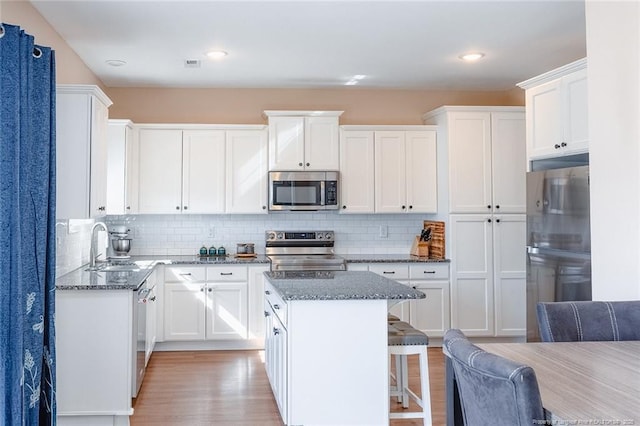 688 Townsend Rd, Raeford, NC 28376 - kitchen with stainless steel appliances, a kitchen island, dark stone counters, decorative backsplash, and recessed lighting