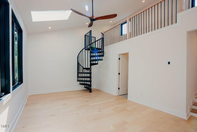 2129 Ridge Rd, Raleigh, NC 27607 - empty room with stairs, plenty of natural light, a ceiling fan, a skylight, and a towering ceiling