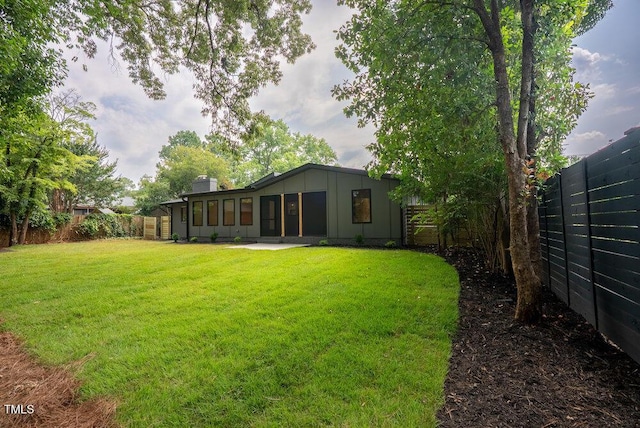 2129 Ridge Rd, Raleigh, NC 27607 - rear view of property featuring board and batten siding, a fenced backyard, a sunroom, and a chimney