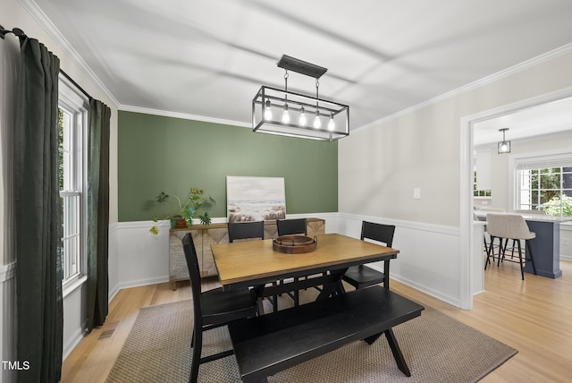 2704 Farnborough Rd, Raleigh, NC 27613 - dining area featuring light wood-style floors, a wainscoted wall, and ornamental molding