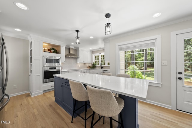 2704 Farnborough Rd, Raleigh, NC 27613 - kitchen with stainless steel appliances, wall chimney exhaust hood, light countertops, white cabinetry, and a breakfast bar area