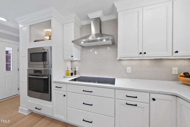 2704 Farnborough Rd, Raleigh, NC 27613 - kitchen with stainless steel appliances, wall chimney range hood, crown molding, light wood-type flooring, and white cabinets