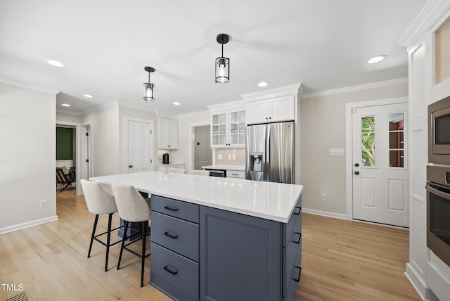 2704 Farnborough Rd, Raleigh, NC 27613 - kitchen with appliances with stainless steel finishes, ornamental molding, white cabinets, recessed lighting, and light wood-type flooring
