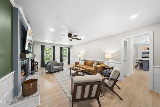 2704 Farnborough Rd, Raleigh, NC 27613 - living room with a fireplace, ceiling fan, light wood-style flooring, recessed lighting, and crown molding