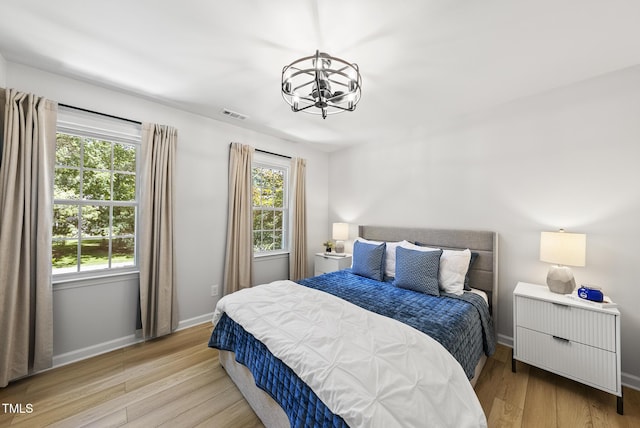 2704 Farnborough Rd, Raleigh, NC 27613 - bedroom with a chandelier, multiple windows, and wood finished floors