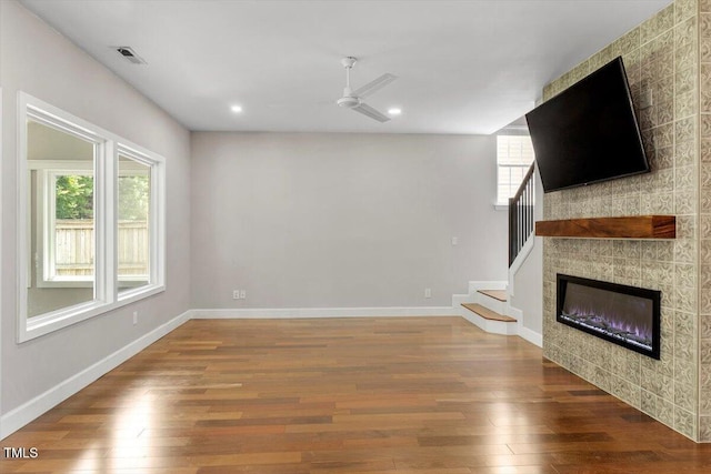 7414 Brandon Allen Ave, Raleigh, NC 27613 - unfurnished living room with plenty of natural light, wood finished floors, ceiling fan, recessed lighting, and stairway