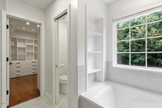 7414 Brandon Allen Ave, Raleigh, NC 27613 - bathroom featuring a bathtub, healthy amount of natural light, a spacious closet, and recessed lighting