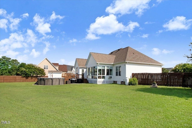 8101 Claybrooke Ct, Willow Springs, NC 27592 - back of house with a sunroom, a fenced backyard, a hot tub, and roof with shingles