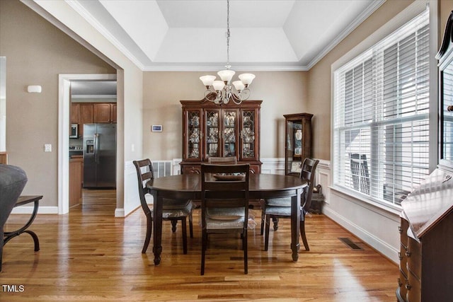 8101 Claybrooke Ct, Willow Springs, NC 27592 - dining room with a tray ceiling, a chandelier, light wood finished floors, and crown molding