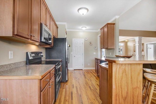 8101 Claybrooke Ct, Willow Springs, NC 27592 - kitchen featuring stainless steel microwave, double oven range, a breakfast bar area, brown cabinetry, and a peninsula