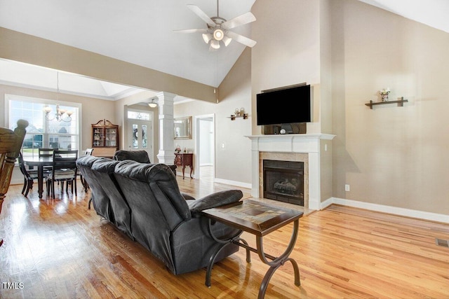 8101 Claybrooke Ct, Willow Springs, NC 27592 - living room with light wood finished floors, a ceiling fan, decorative columns, a tile fireplace, and high vaulted ceiling