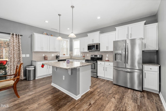78 N Porcenna Ln, Clayton, NC 27527 - kitchen featuring appliances with stainless steel finishes, a center island, tasteful backsplash, white cabinetry, and recessed lighting