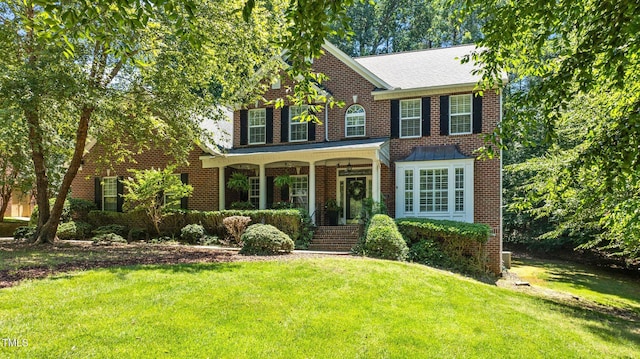 1008 Old Meetinghouse Way, Raleigh, NC 27615 - colonial house featuring a front yard, a porch, and brick siding