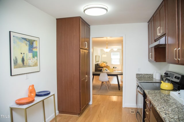 4028 Chaucer Dr, Durham, NC 27705 - kitchen featuring stainless steel range with electric stovetop, under cabinet range hood, light wood-style floors, light stone counters, and a desk