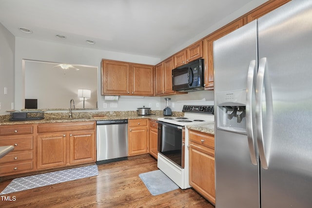 8532 Swarthmore Dr, Raleigh, NC 27615 - kitchen with appliances with stainless steel finishes, light wood-style flooring, light stone countertops, recessed lighting, and ceiling fan