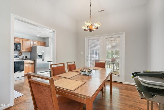 8532 Swarthmore Dr, Raleigh, NC 27615 - dining room featuring a chandelier, wood finished floors, and a towering ceiling