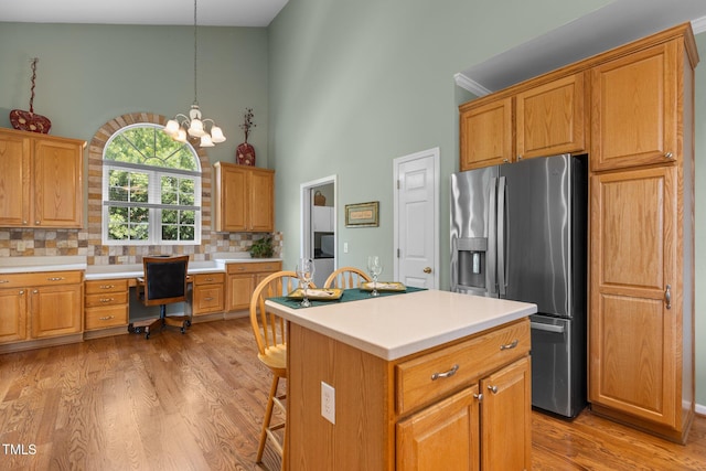 2104 Brockfield Ct, Raleigh, NC 27614 - kitchen featuring stainless steel refrigerator with ice dispenser, a towering ceiling, built in study area, tasteful backsplash, and light wood finished floors