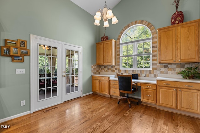 2104 Brockfield Ct, Raleigh, NC 27614 - home office with high vaulted ceiling, light wood-style flooring, built in desk, french doors, and a chandelier