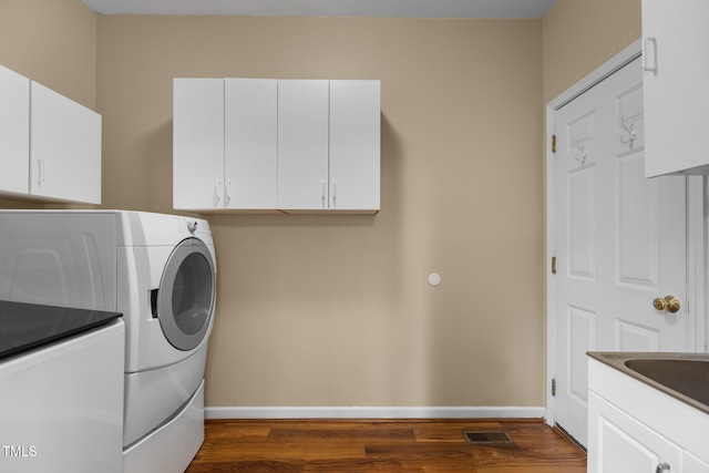 2104 Brockfield Ct, Raleigh, NC 27614 - washroom with washing machine and dryer, dark wood-type flooring, and cabinet space