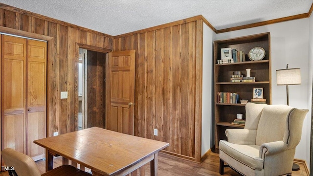 424 Roy Carver Rd, Semora, NC 27343 - living area with crown molding, wooden walls, wood finished floors, and a textured ceiling