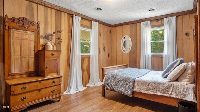 424 Roy Carver Rd, Semora, NC 27343 - bedroom with a textured ceiling, wood finished floors, and wooden walls