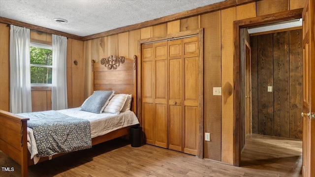424 Roy Carver Rd, Semora, NC 27343 - bedroom with light wood-type flooring, wood walls, and a textured ceiling