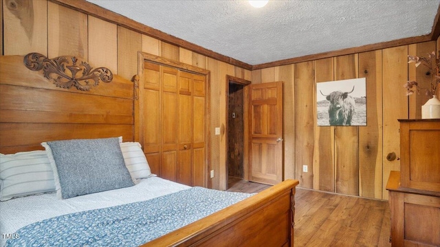424 Roy Carver Rd, Semora, NC 27343 - bedroom featuring light wood finished floors, a textured ceiling, wooden walls, and ornamental molding