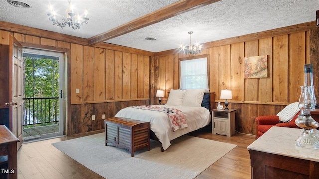 424 Roy Carver Rd, Semora, NC 27343 - bedroom with a chandelier, wood walls, access to exterior, light wood-style floors, and beamed ceiling
