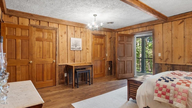 424 Roy Carver Rd, Semora, NC 27343 - bedroom with wood walls, access to exterior, a textured ceiling, a chandelier, and wood finished floors