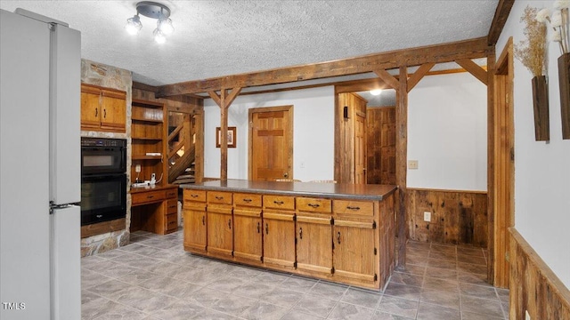 424 Roy Carver Rd, Semora, NC 27343 - kitchen featuring freestanding refrigerator, a wainscoted wall, dark countertops, a textured ceiling, and wood walls