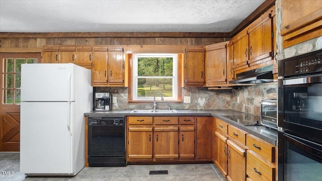 424 Roy Carver Rd, Semora, NC 27343 - kitchen featuring black appliances, brown cabinets, under cabinet range hood, backsplash, and a textured ceiling