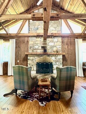 424 Roy Carver Rd, Semora, NC 27343 - sitting room featuring healthy amount of natural light, wood-type flooring, a wooden ceiling with exposed beams, wooden walls, and high vaulted ceiling