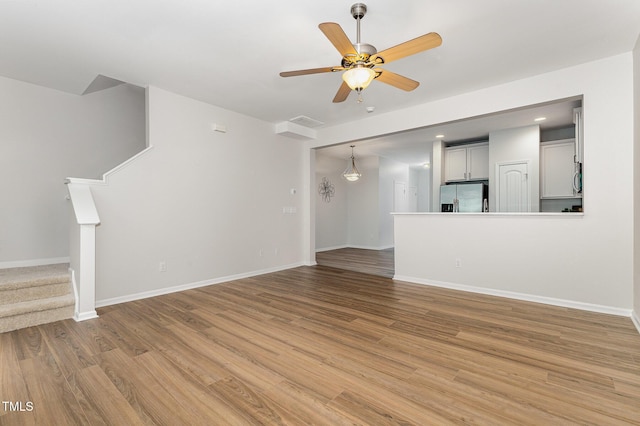 14309 Foxcroft Rd, Raleigh, NC 27614 - unfurnished living room featuring stairway, a ceiling fan, and light wood-style floors